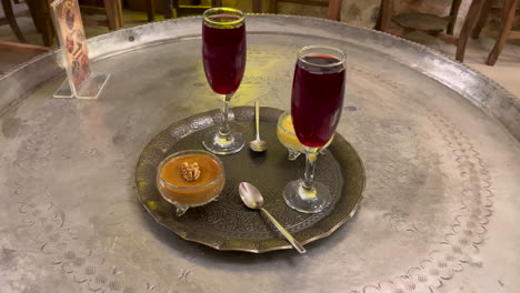 turkey, mardin, traditional sweets presentation with syrups by the side in a sweets shop at mardin. dessets on an traditional copper tray on a copper traditionally decorated tray table.