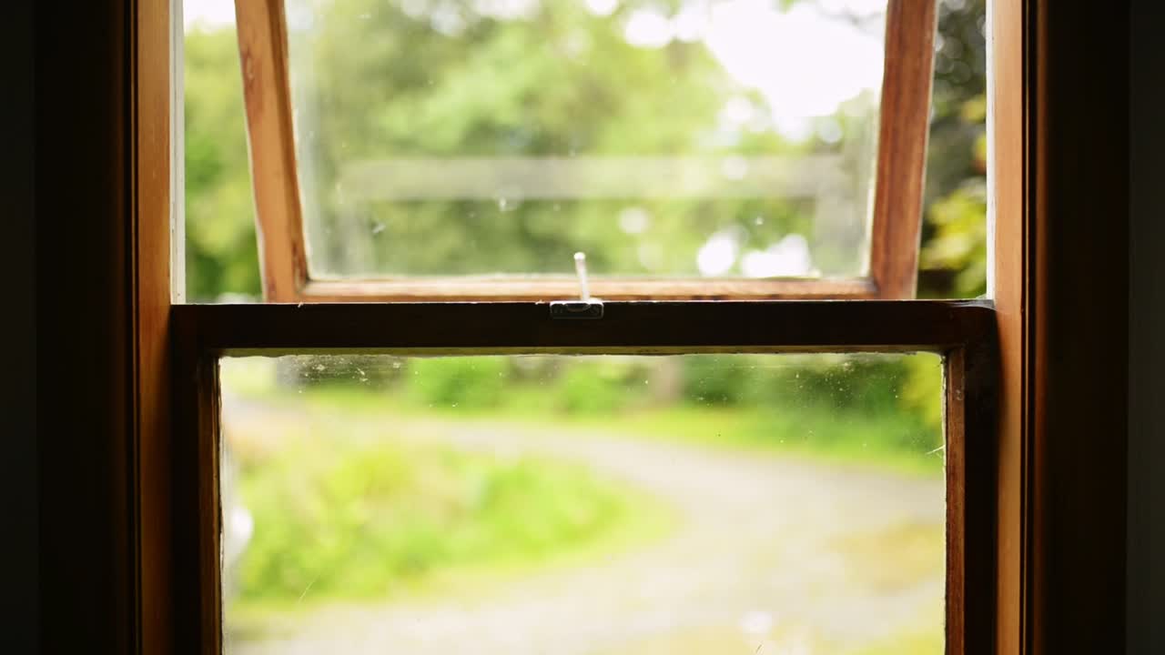 오래된 나무 창을 닫기 위해 프레임에 손을 뻗다