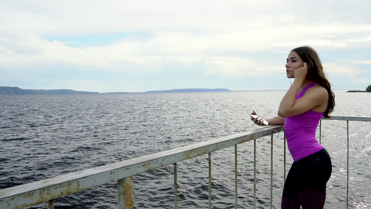 mujer escuchando música junto al río