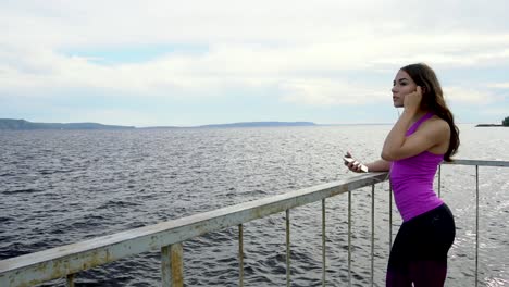 mujer escuchando música junto al río