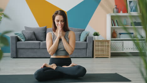mujer practicando meditación de yoga en casa