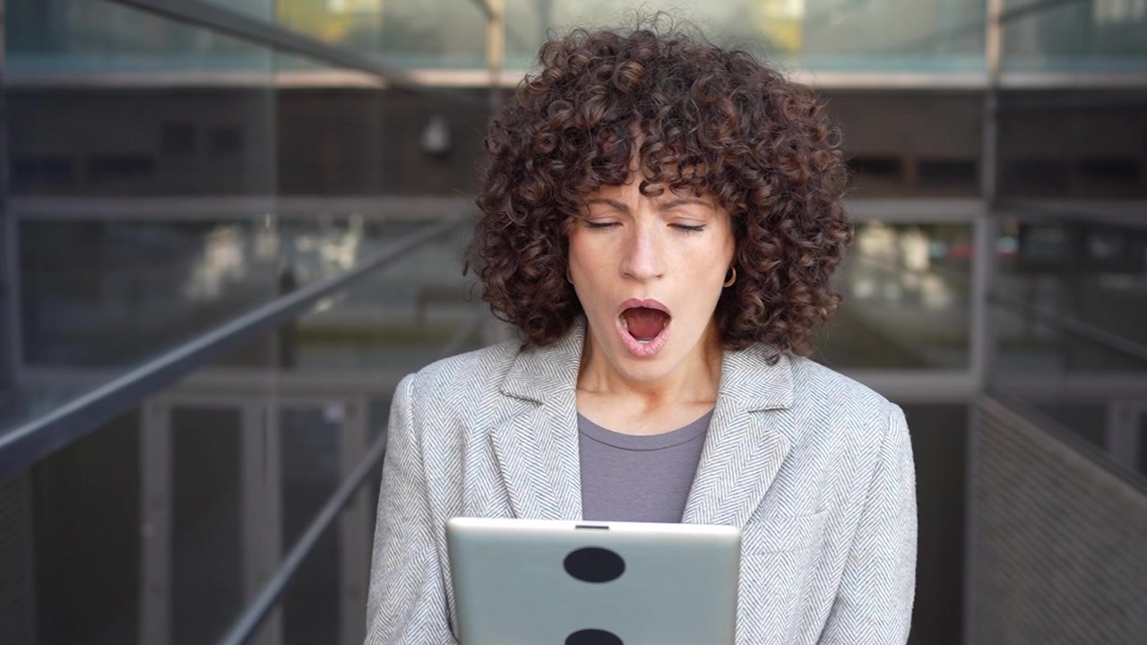 Una donna professionista usa il suo tablet in un contesto urbano, mettendo in mostra le sue capacità professionali.