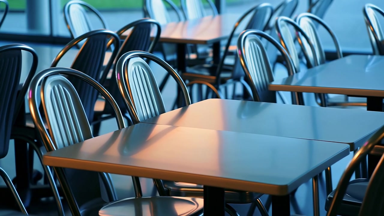 Empty modern cafe interior showing parallel rows of glossy rectangular tabletops and curved tubular metal chairs with slatted backs, gentle camera shift reveals repeating seating pattern, reflections