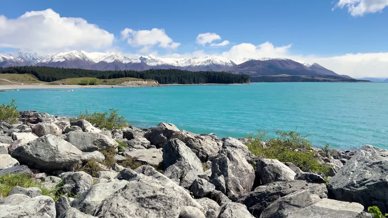 Scenic lake view with mountains, clear skies, and tranquil blue waters