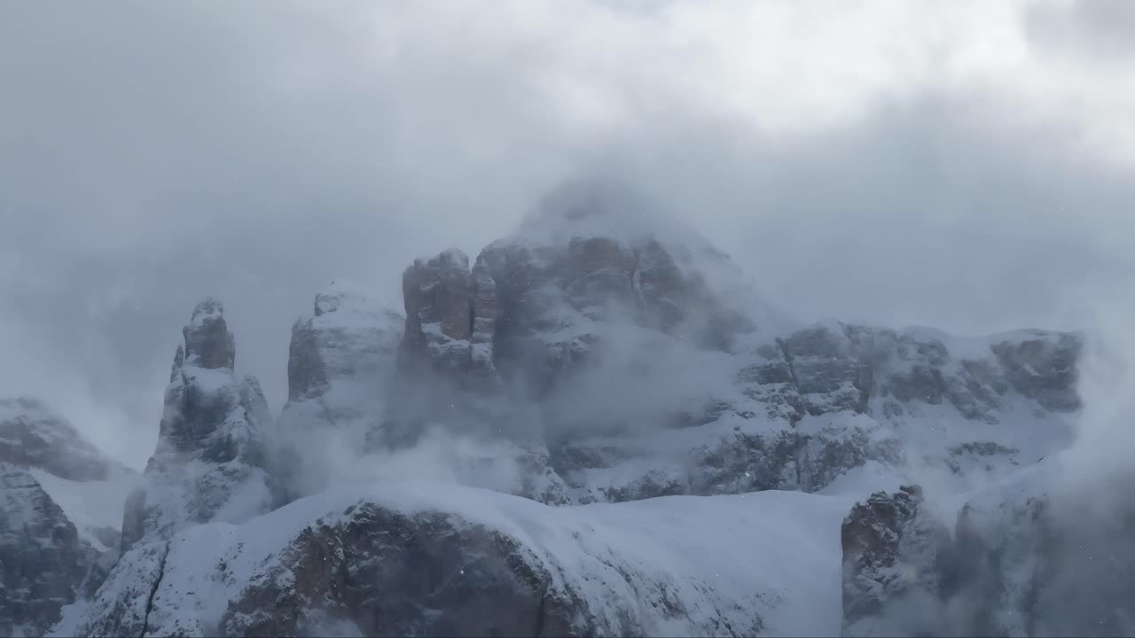 las nubes de niebla cubren los picos nevados de la cordillera de los dolomitas en un frío día de invierno