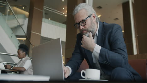 businessman working on laptop in a hotel lobby