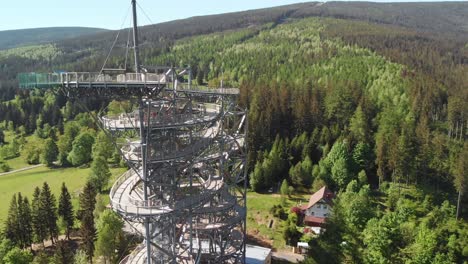 aerial orbit over the observation tower located in the middle of the forest in sudety mountains