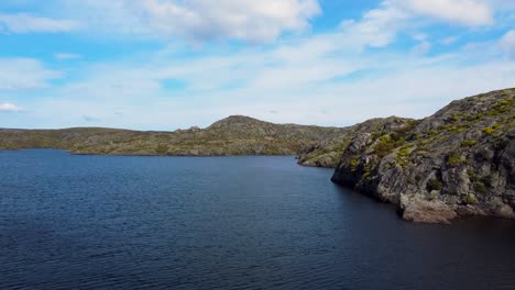 Rocky-Cliffs-Along-Open-Lake-Of-Embalse-De-Las-Tejoneras,-Spain