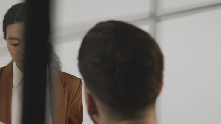Male Candidate Being Interviewed In Office For Job By Female Interviewer Viewed Through Window 4