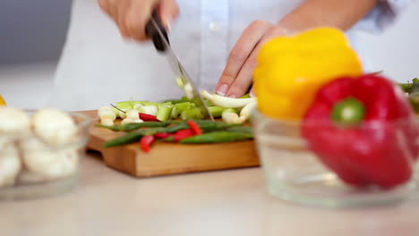 mujer cortando verduras en el mostrador