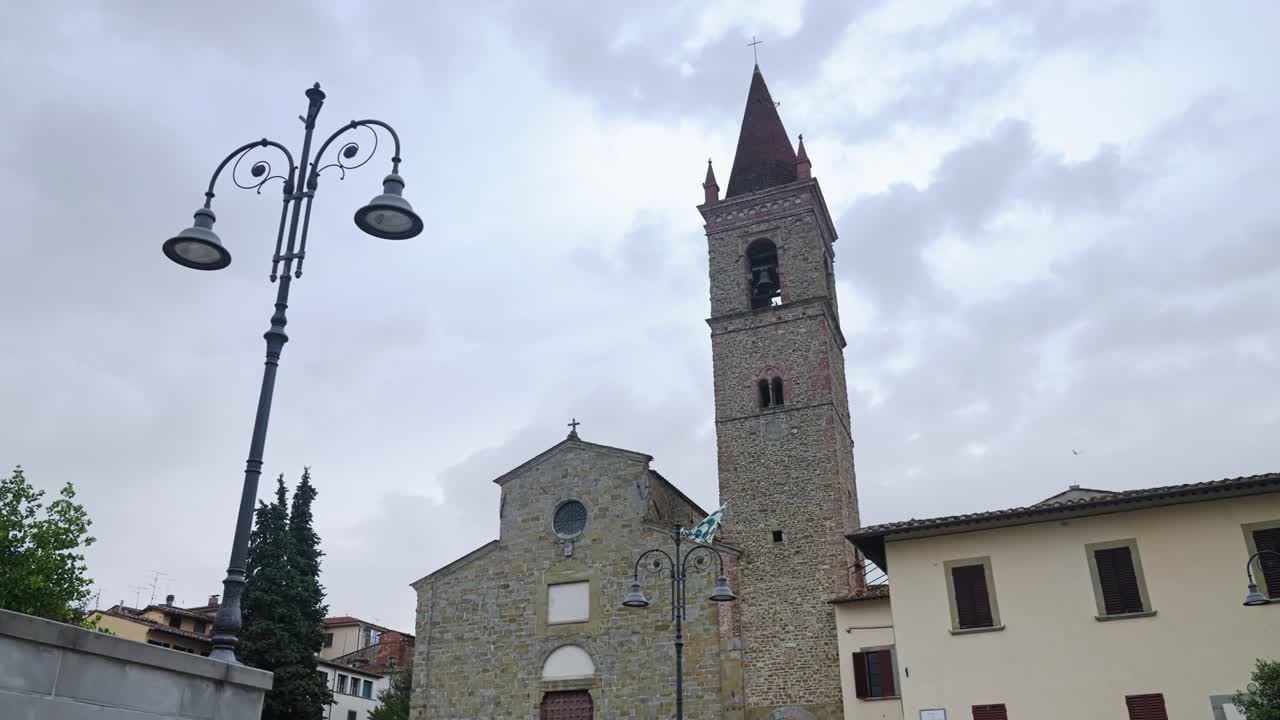 Chiesa di Sant'Agostino contro il cielo drammatico sopra la Piazza di Arezzo in Toscana, Italia