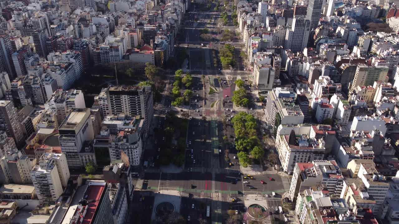 vista aérea sobre la famosa avenida 9 de julio con tráfico rodeado de rascacielos en buneos aires - river plate en el fondo - tiro inclinado hacia arriba