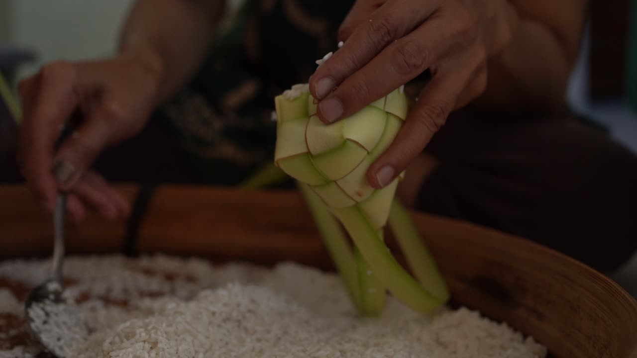 el proceso de poner arroz en el ketupat, antes de cocinar