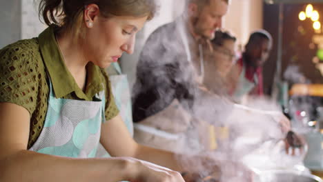 mujer cocinando pasta en una olla durante una clase magistral culinaria