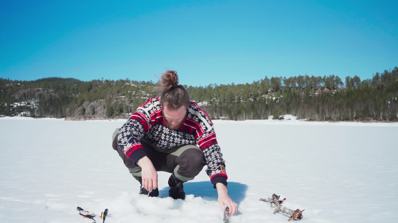 persona cavando un agujero en un lago congelado en un día soleado de la temporada de invierno