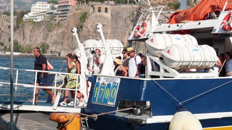 turistas que se suben a un barco en sorrento, italia