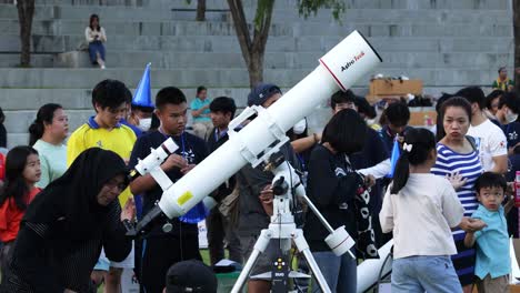 crowd observing through a large telescope outdoors