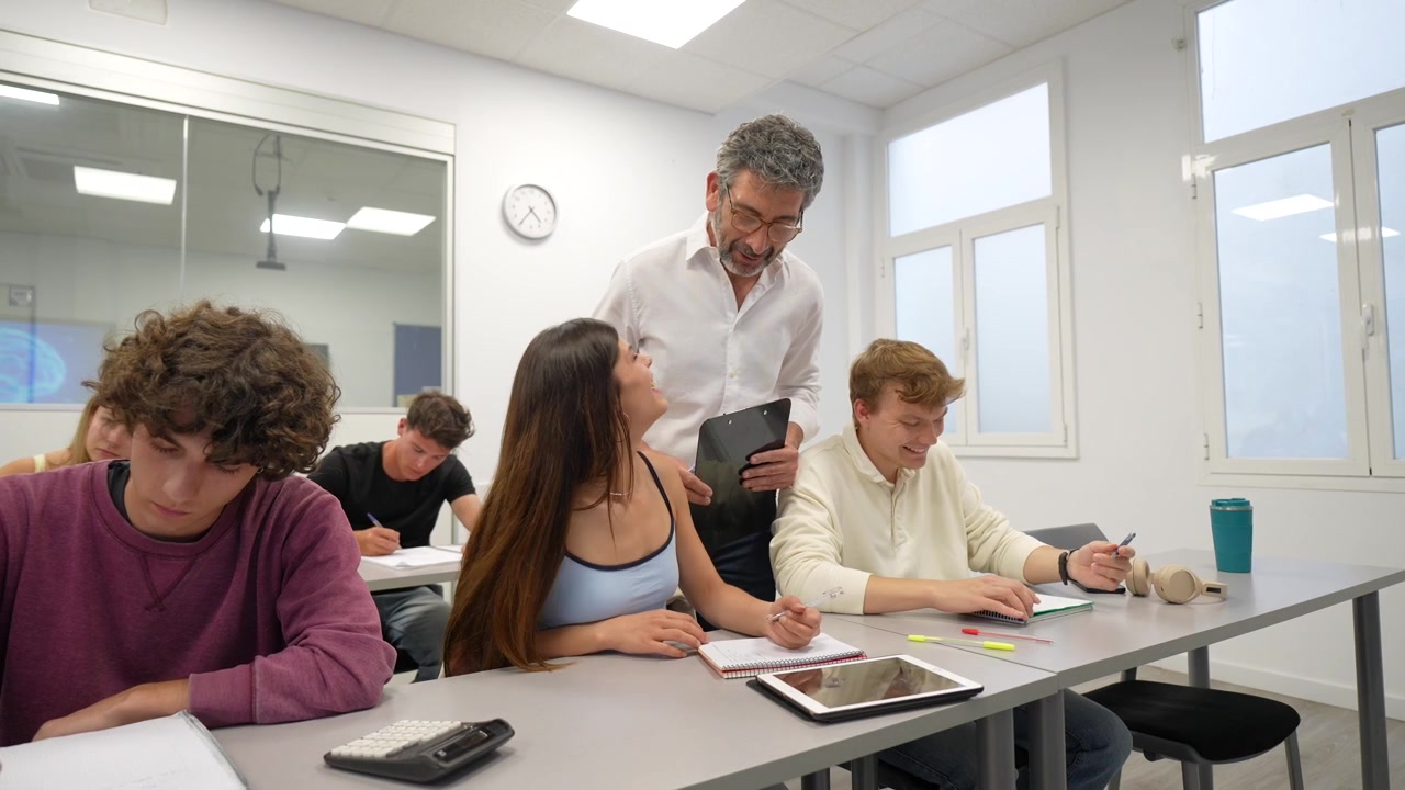 Insegnante che aiuta gli studenti con il loro lavoro in un'aula moderna.