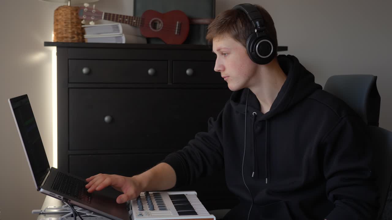 Young artist creating new sounds and tracks with digital equipment