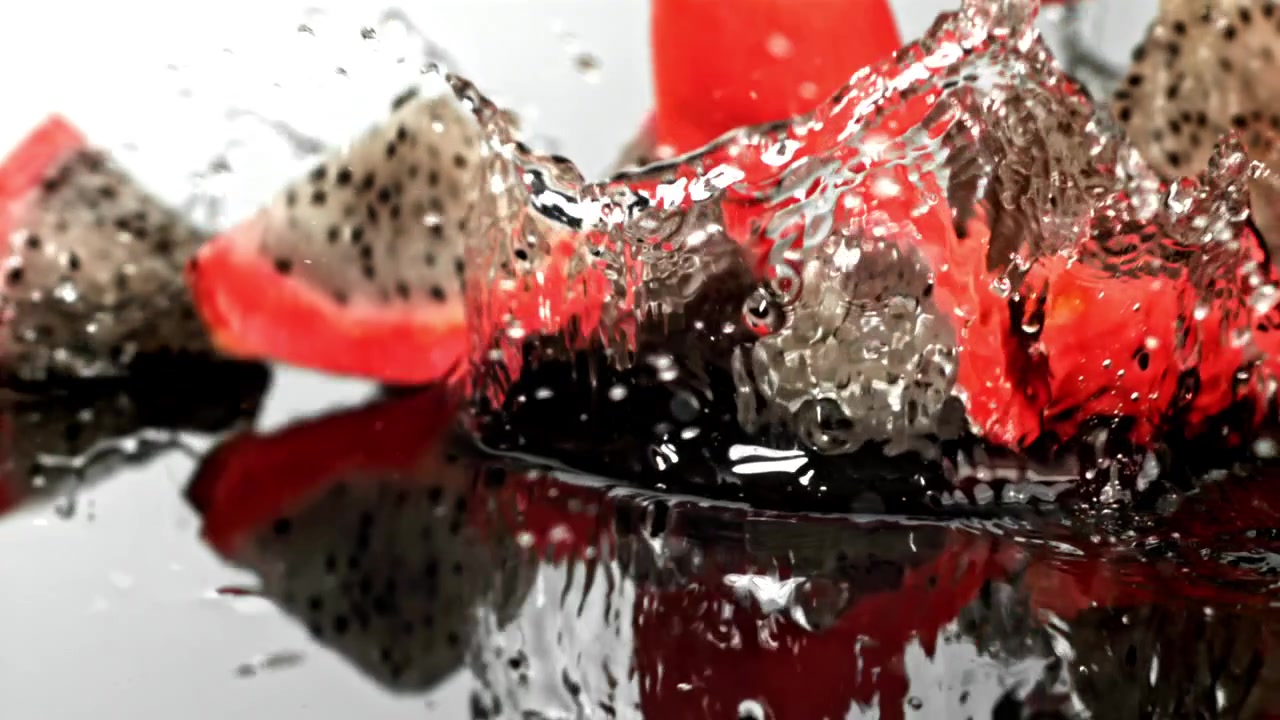 Fresh Dragon Fruit Chunks Falling into Water in Slow Motion