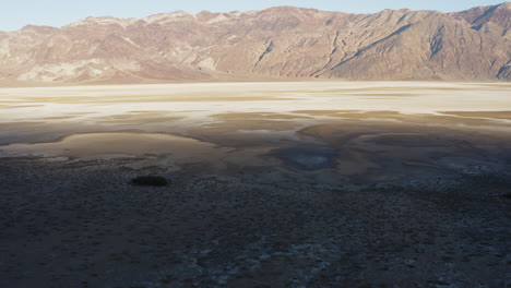 aerial dry desolate desert landscape view of emigrant canyon, drone fly above badwater basin an endorheic basin in death valley national park during a hot sunny day revealing amazing unexplored area