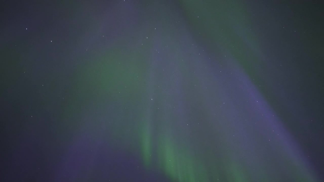 Vibrante Aurora Boreale che Danza sulle Cime Montuose Innevate