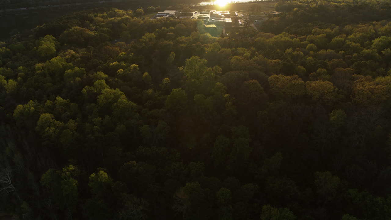 lenta panorámica aérea sobre los árboles revelando mocasin bend y el río tennessee iluminado por la luz dorada de la puesta de sol