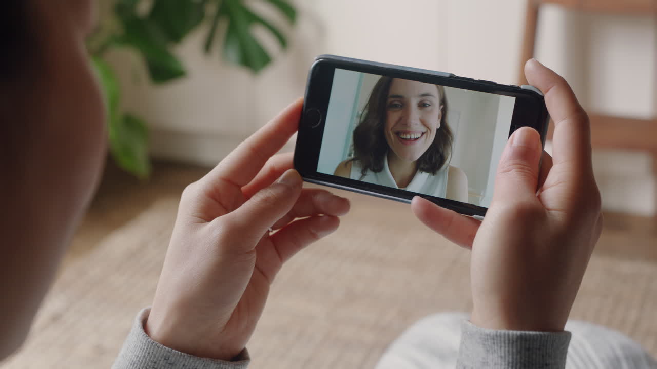 mujer joven teniendo video chat usando teléfono inteligente en casa hablando con un amigo mostrando peinado compartiendo estilo de vida disfrutando de la comunicación en línea