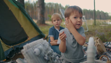 dangerous play with knife of children two boys at picnic in tent camp kids without parental supervision