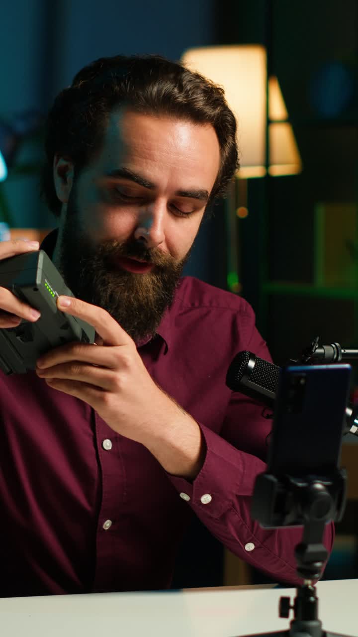 Vlogger di video verticali mostra le specifiche del dispositivo di ricarica, registrando con il telefono