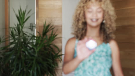 Young-biracial-woman-displays-a-vote-badge-at-home