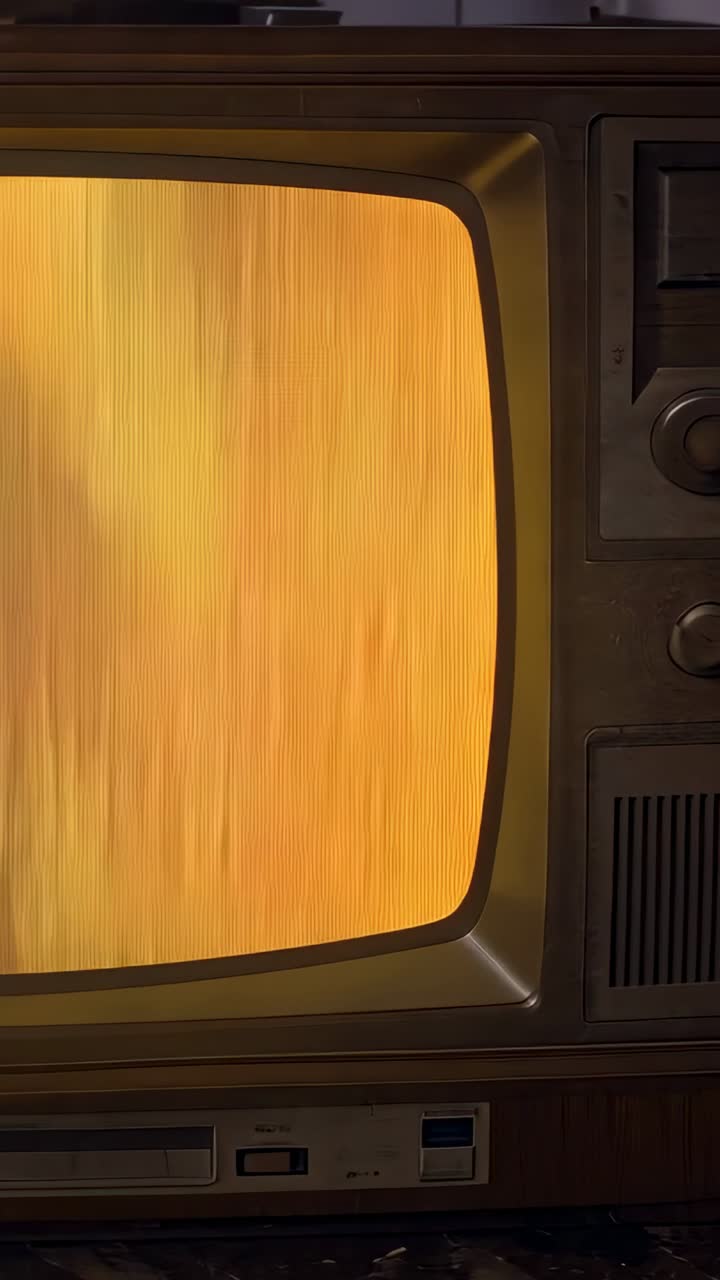 Vertical video: Shifting retro CRT TV showing amber streaks on wood table, revealing control knobs