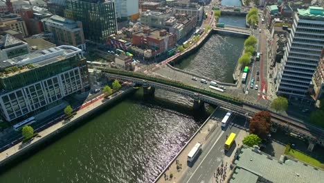 a train passing over the river liffey, next to dublin custom house quay in dublin city centre, lenister, ireland on a bright and sunny day. filmed in 4k, 60fps and with rec709 color.