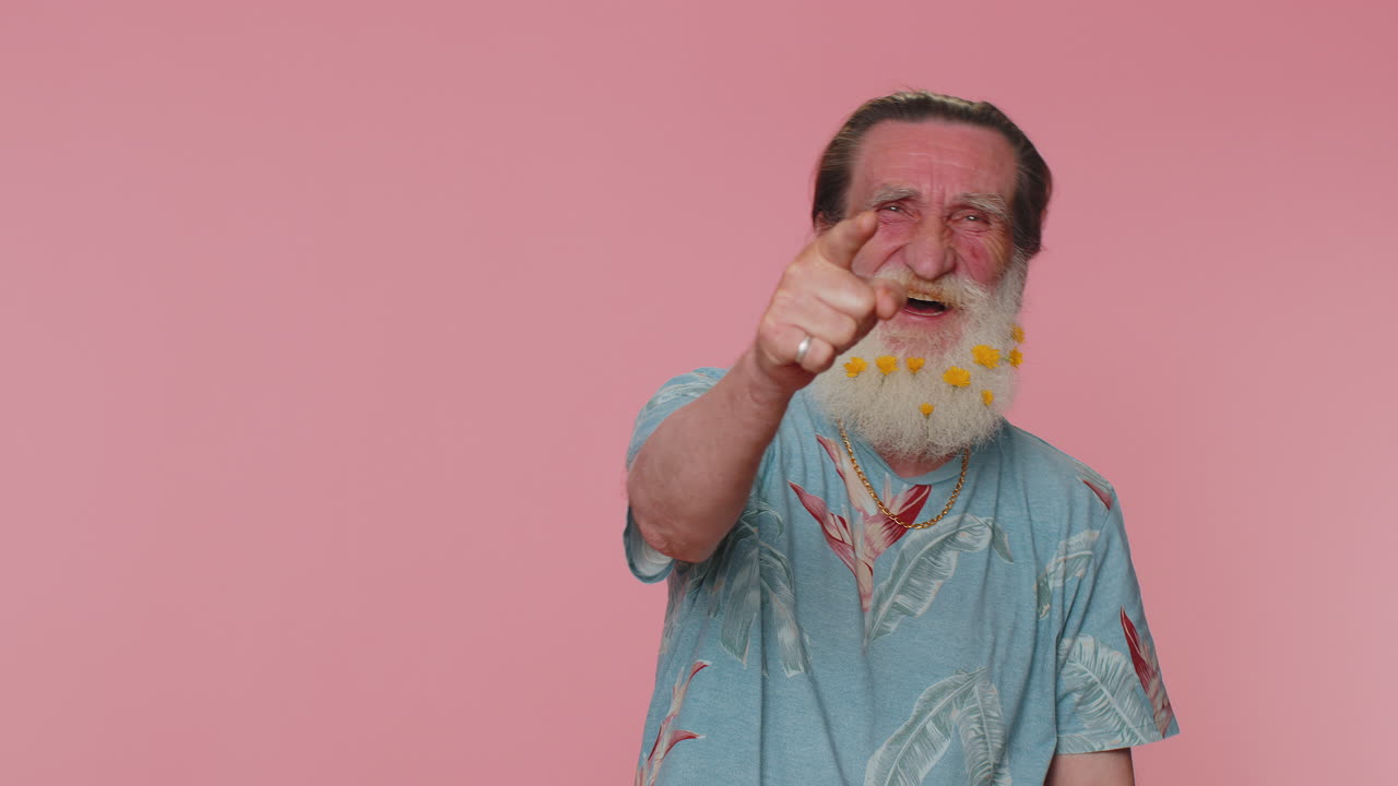 hombre señalando con el dedo a la cámara, riendo en voz alta, burlándose de la apariencia ridícula, broma divertida