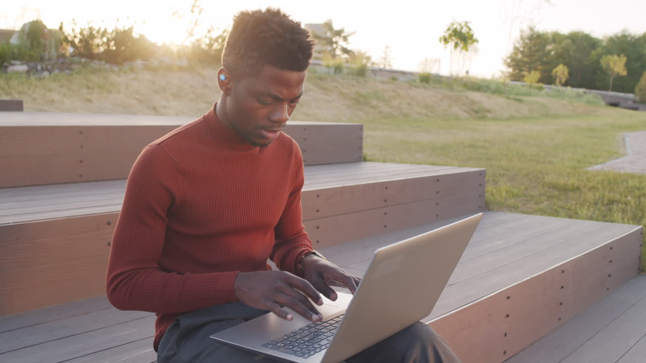 African American Business Man Writing E-Mail on Laptop Outdoors