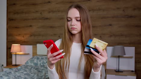 woman hold in hands credit bank card using mobile cell phone order delivery, online shopping payment