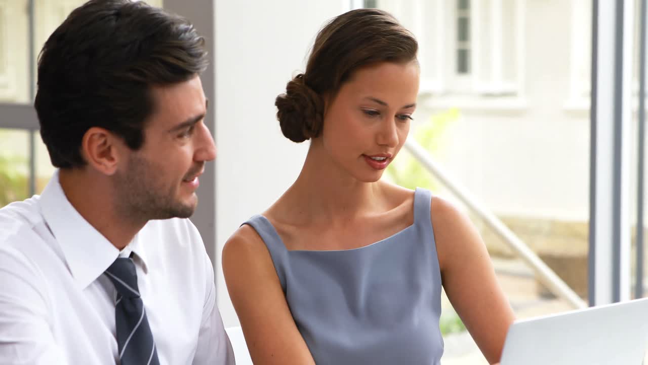 ejecutivos de negocios discutiendo sobre una computadora portátil 4k