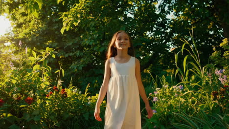 a young girl in a white dress walks through a beautiful, sunlit garden
