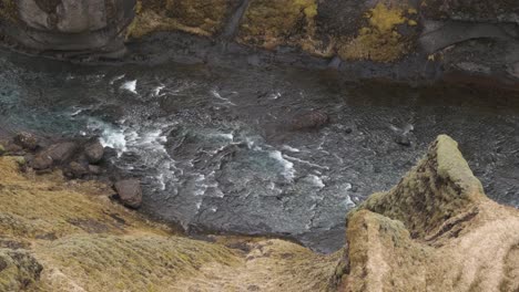 corriente que fluye en el cañón fjadrargljufur, islandia. angulo alto