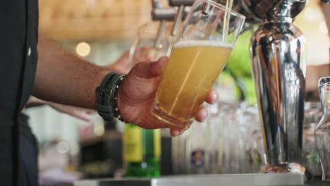 Closeup-of-Hands-pouring-a-fresh-beer-at-the-bar-until-its-full-during-a-hot-summer-day-in-Basel,-Switzerland