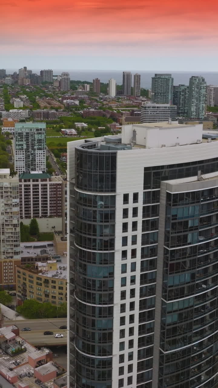 Scenery of beautiful Chicago with diverse buildings. Cars crossing bridges over the river. Pink sunset at background. Vertical video