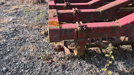 old farm equipment overgrown and lying abandoned in a field rising shot over equipment to field beyond