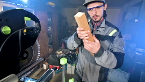 a young carpenter installs a wooden work piece in a circular sawing machine.