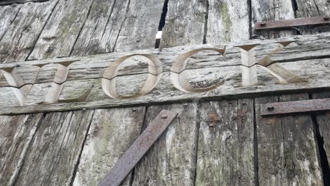 palabra de desbloqueo desgastada tallada envejecida en un viejo tablón de madera puerta oxidada dolly izquierda