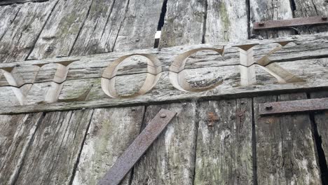 aged carved weathered unlock word in old timber plank rusty doorway dolly left