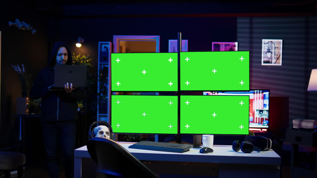 사이버 범죄자가 노트북을 들고 모형 디스플레이가 있는 아파트에서 고 있습니다.