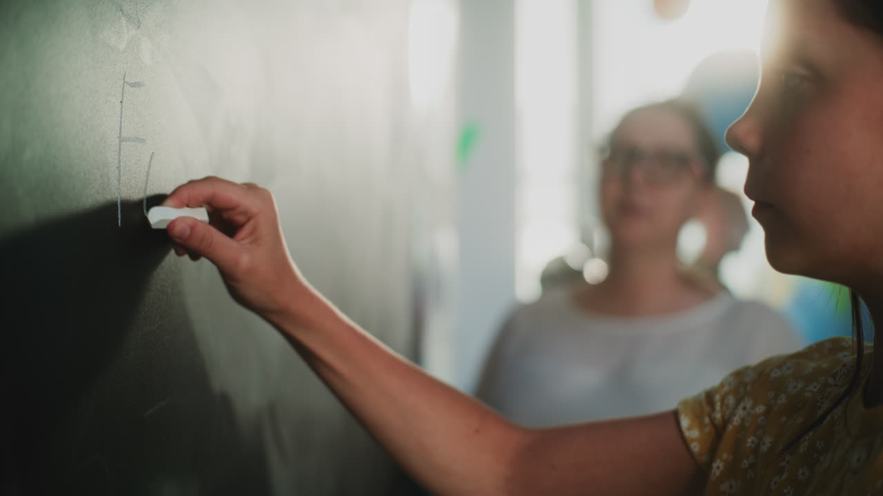 Close Up Shot of Primary School Girl Writing Word on the Board with Chalk