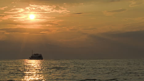 Sailing-ship-in-quiet-sea-at-sunset