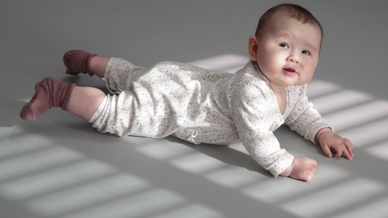 bebé feliz sonriendo mientras está acostado boca abajo - tiempo boca abajo - toma de cuerpo completo