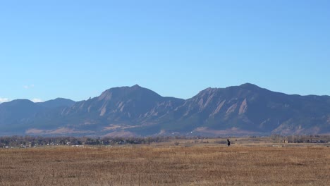 Man-walking-on-a-trail-against-a-background-of-mountains